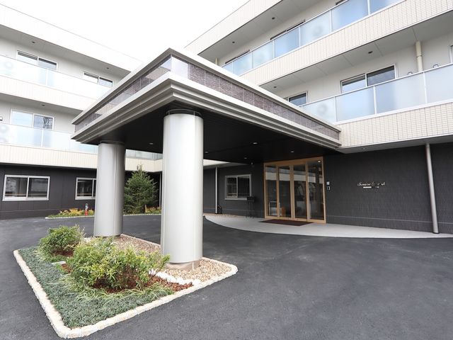 清潔なエントランスの風景 玄関 広々としたエントランスは、明るく開放的な雰囲気が感じられ、訪れる方を温かくお迎えします。安全に配慮した設計が垣間見える入り口です。