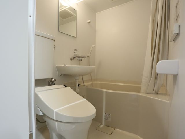 清潔なトイレ空間 ユニットバス 清潔で明るいトイレとバスルームです。手すりも完備され、安全に配慮された設計となっています。