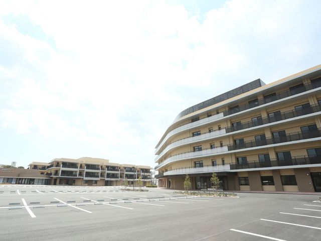 広々とした駐車場の外観 外観 広い駐車場を有するモダンな建物です。通勤時の便利さが期待できる職場環境を提供しています。