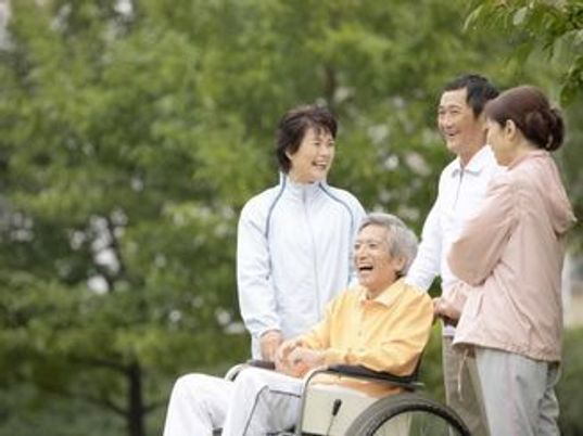 車椅子の利用者と笑顔のスタッフ