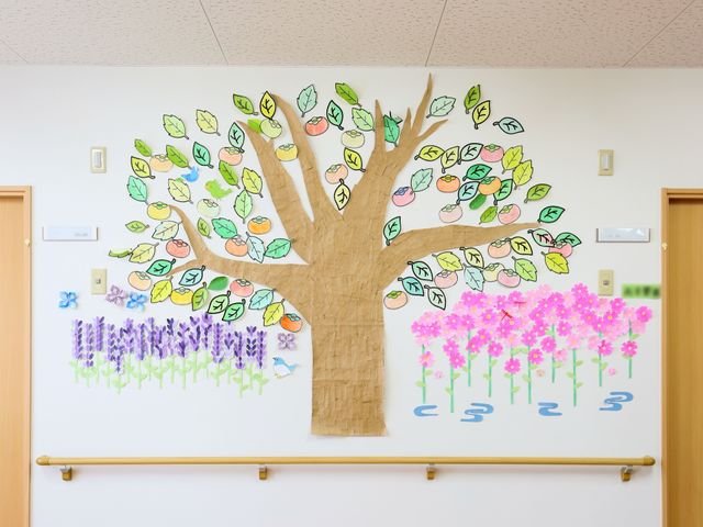 壁に描かれた手作りの木 インテリア 壁に手作りの絵が飾られた、明るく暖かな雰囲気の空間です。手作りの装飾が日々の活動を彩っています。