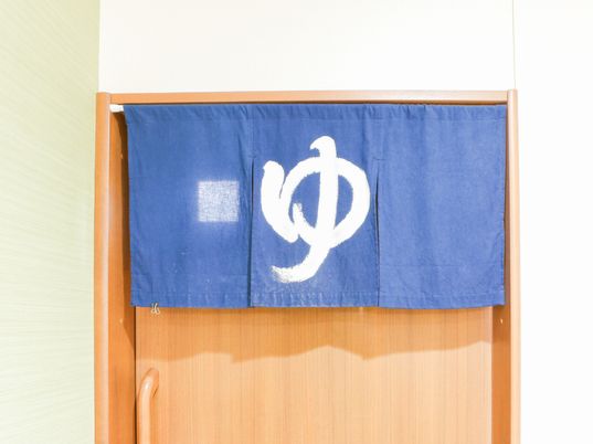 青い暖簾と木製扉