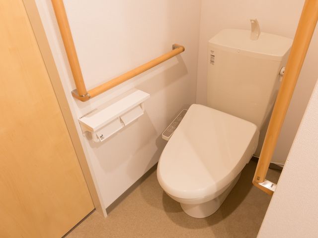 バリアフリートイレ トイレ 手すりが備えられた清潔感のあるトイレ空間です。利用者の安全と快適さを考慮した設計になっています。
