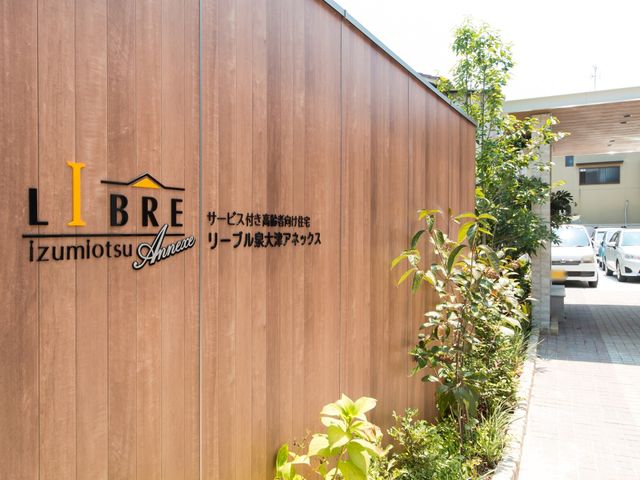 ケアの看板のある施設外観 看板 安定感のある外観の施設で、やりがいを感じながら働いてみませんか？専門性を生かして、一緒に支援をしましょう。