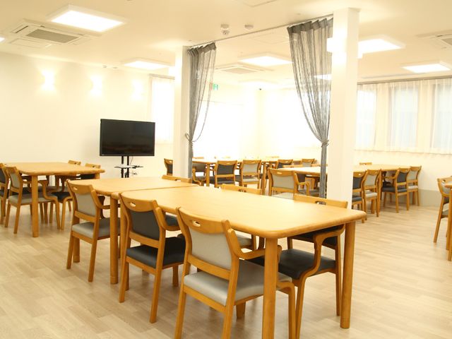 木製テーブルのダイニング 共有スペース 木製のテーブルと椅子が整然と配された明るい食堂です。共有された空間で、くつろぎながら食事ができます。
