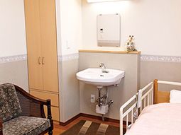 居室の洗面所とベッド