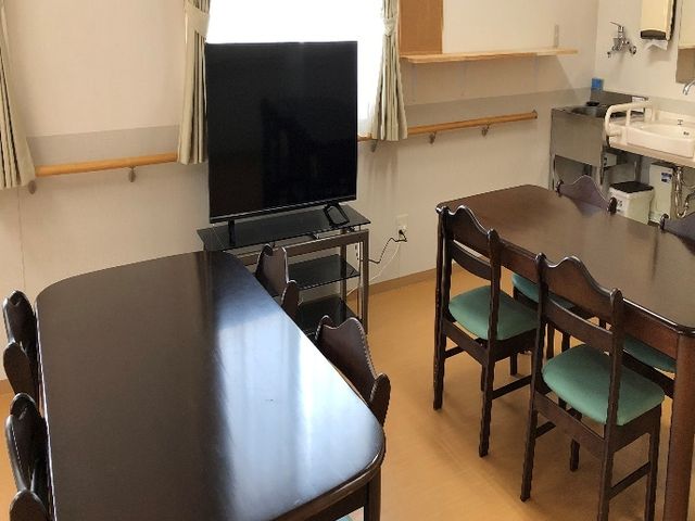 共有スペースの居室 食堂 広々とした居室には、大型テレビや食事を共にするためのテーブルが配されており、快適な日常生活を支える環境が整っています。
