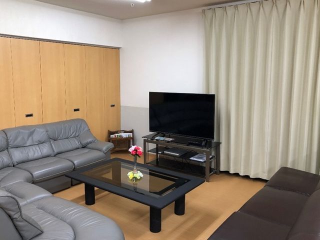 快適な居住スペース 談話スペース 心地よい憩いの場が提供されており、共有リビングでゆったりと過ごせる空間が整っています。ソファや大画面のテレビが配置され、居心地の良い雰囲気が漂っています。
