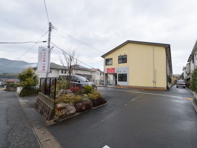 施設の外から見た建物 外観 広々とした敷地に心温まる色合いの建物があり、静かな環境での勤務が期待できます。