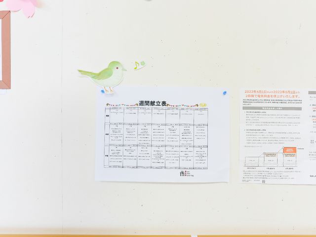 スケジュール表を示す壁 掲示物 丁寧に整理されたスケジュール表は、働くスタッフが一日の流れを把握しやすい工夫がされています。