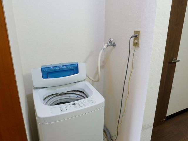 洗濯機と壁の隅 共有スペース コンパクトに設置された洗濯設備です。日常のお洗濯も手軽に行えます。