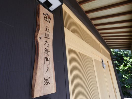 玄関には施設名を印字した木製の板を設置している。大きな文字で印字しており道路からでも確認することができる。