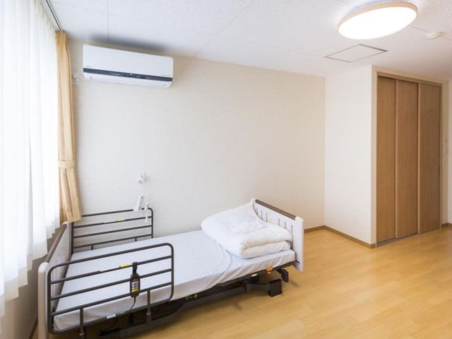 明るい居室空間 居室 自然光があふれる部屋で、快適な環境が整っています。介護ベッドが配置されています。