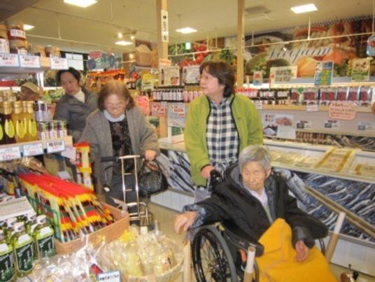 買い物する人々と車椅子の女性