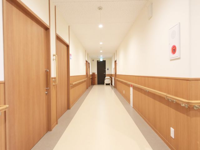 清潔な施設の廊下 通路 手すりが整備された明るい廊下です。廊下は清潔に保たれ、ゆったりとした空間が確保されていますので、安心してご勤務いただけます。