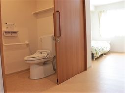 居室のトイレとベッド
