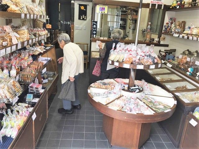 お菓子の店内様子 外出支援 スタッフの接客の一場面です。丁寧な対応でお客様の心をつかみ、快適なお買い物時間を提供しています。
