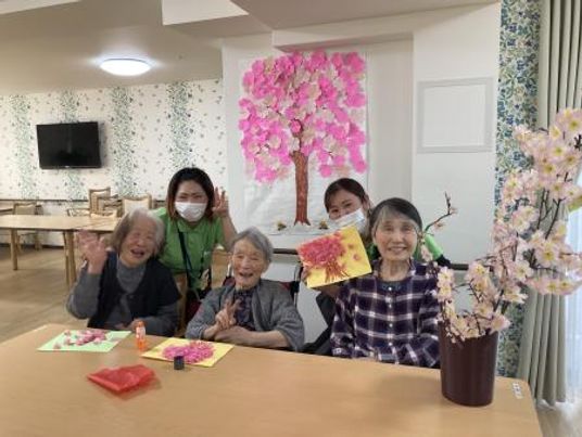 桜の壁画と共に微笑む人々