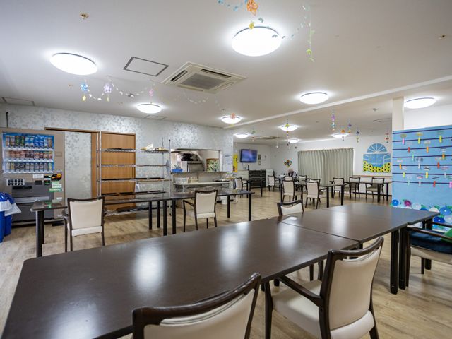 明るい食堂 食堂   広い食堂にテーブルがゆったり配置され、落ち着いて食事の準備がしやすそうです。明るい照明と整った動線で、働きやすさが感じられます。