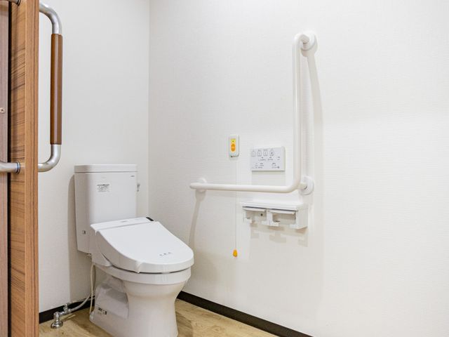 手すり付きトイレ トイレ 広めのトイレに手すりが設置され、立ち座りを支えやすいつくりです。木目の床で、落ち着いた印象です。