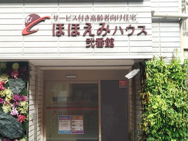 施設のエントランス正面 玄関 暖かい雰囲気のエントランスが迎えてくれます。ゆとりのある入り口は、働く環境にも配慮されている様子です。