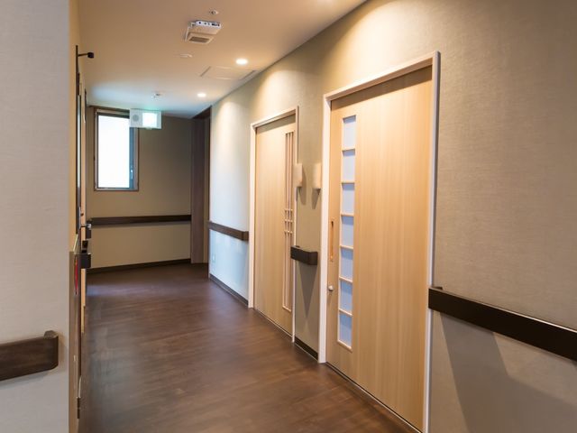 廊下の明るい通路 廊下 手すりが設置された清潔感のある廊下です。安全かつ快適にご移動いただける環境が整っています。