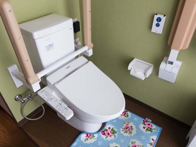 バリアフリートイレ設備 トイレ 手すり付きのモダンなトイレは、使用者の安全と快適さを考慮しています。機器の操作も簡単で、全ての方が安心してご利用いただける設計になっています。