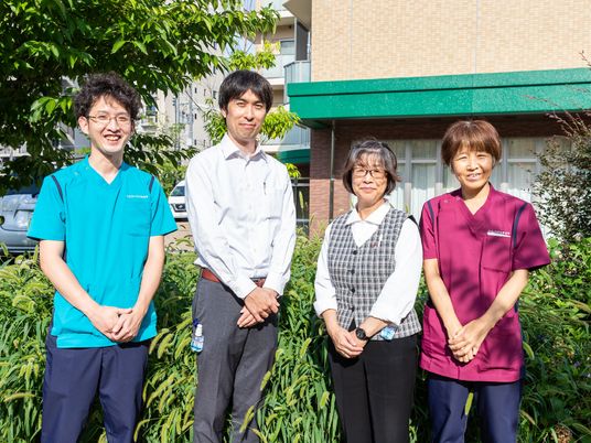 笑顔のスタッフ４人立つ