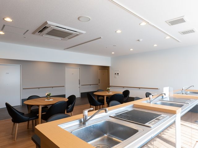 清潔なキッチンダイニング 談話スペース 広々としたダイニングでは自由に調理や食事が楽しめます。モダンな家具が配され、安心して就業できる環境です。