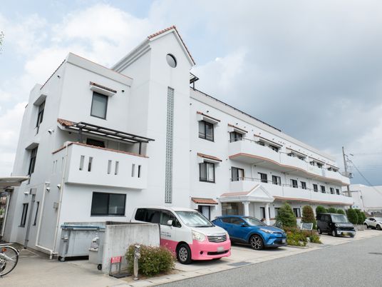 白い建物と駐車場の外観