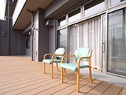 部屋の外に設けられているウッドデッキ。椅子が二つ並べて置いてある様子