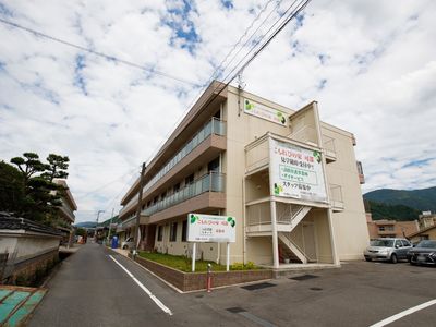 緑の山々背景の施設外観