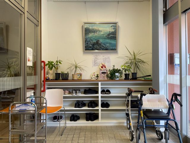 車椅子と棚のエントランス エントランス 植物が並ぶ棚と車椅子が用意された場所です。明るい雰囲気が心地よさを演出しています。