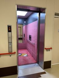 ピンクの広々とした乗り場のエレベーター