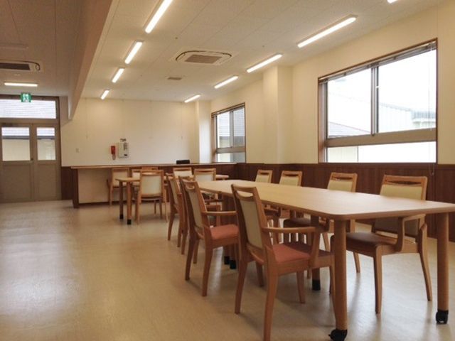 明るい食堂のテーブルと椅子 食堂1 広々とした食堂は自然光が差し込む設計となっており、ゆったりとした食事の時間を過ごせるよう配慮されています。