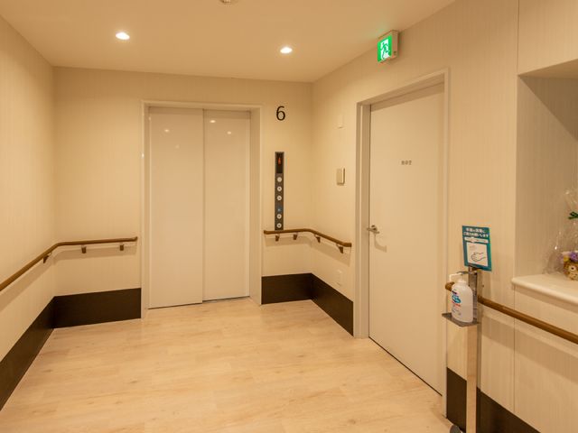 廊下にエレベーターと手すり エレベーター 手すりが設置されたきれいな廊下です。安心して歩行できる環境が整っており、清潔感が感じられます。
