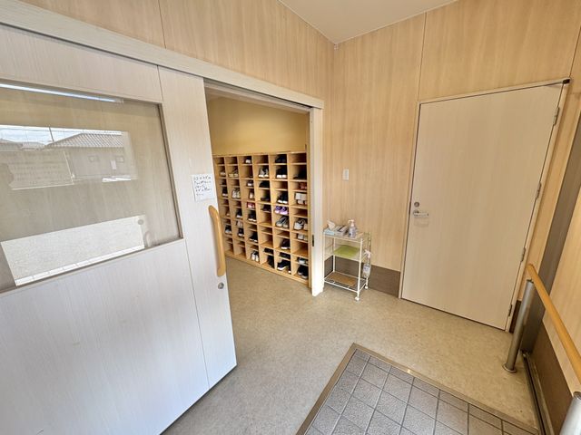 明るい玄関の靴棚 エントランス   木目調で落ち着いた玄関です。靴棚が整然と並び、出入りのしやすさが感じられます。