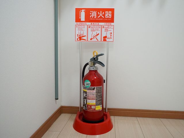 消火器と説明看板 共有スペース 万が一の事態に備え、消火器が設置されており、使い方が明示されています。安心して日々の業務に取り組める環境です。