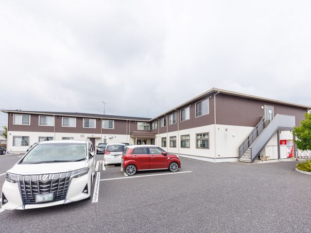 施設の外観と駐車場 外観   広い駐車場があり、建物の出入口へ車で近づきやすい印象です。明るい外壁で、来訪時の動線も確認しやすそうです。