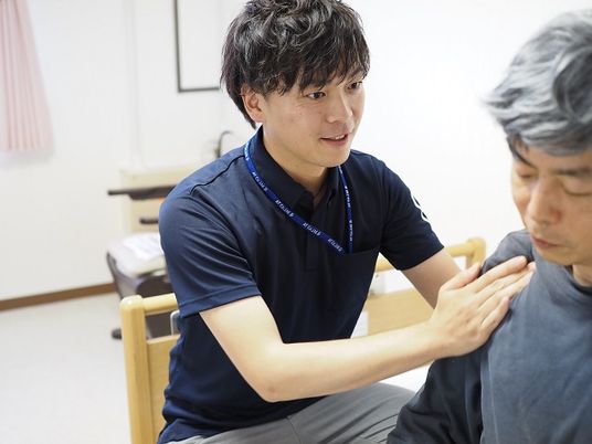 優しく手を触れるスタッフ