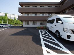 施設前の駐車場と送迎車
