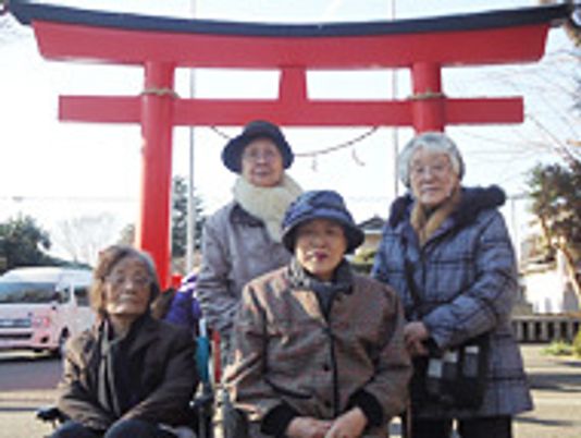 笑顔の利用者と鳥居