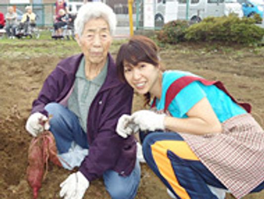 笑顔の二人と収穫のさつまいも