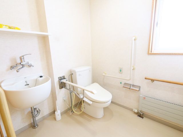 バリアフリーの明るいトイレ トイレ 手すり付きで安心のトイレスペースです。清潔感があり、すべての方が使いやすい環境が整っています。