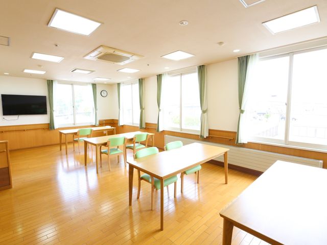 広々とした明るい食堂 共有スペース ゆとりのある木の床の食堂で、明るい窓から自然光が差し込んでいます。皆で集まり、食事や交流を楽しむことができる温かい場所です。