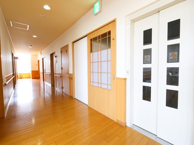 明るい廊下の様子 通路 ゆったりとした通路が確保された廊下です。手すりが設置されており、安全に移動できる環境が整っています。