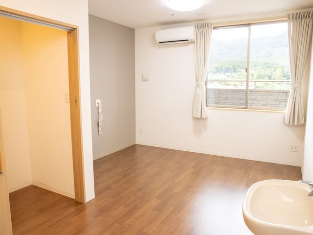 明るい居室の一角 居室 広々とした空間の居室からは、窓越しに自然景色が望め、心安らぐ環境です。快適なエアコン設備も完備されております。