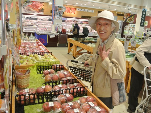 買い物を楽しむ笑顔の高齢者 買い物 買い物中の高齢者が笑顔で応じており、手に持ったカゴが日常の一コマを物語っています。