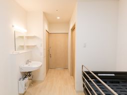 居室の洗面台とベッド