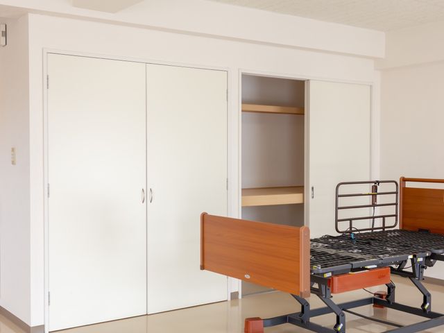 居室のベッドとクローゼット 居室 広々とした居室には、使い勝手の良いクローゼットと快適なベッドを完備しておりますので、ご利用の方に安らぎの空間を提供できます。